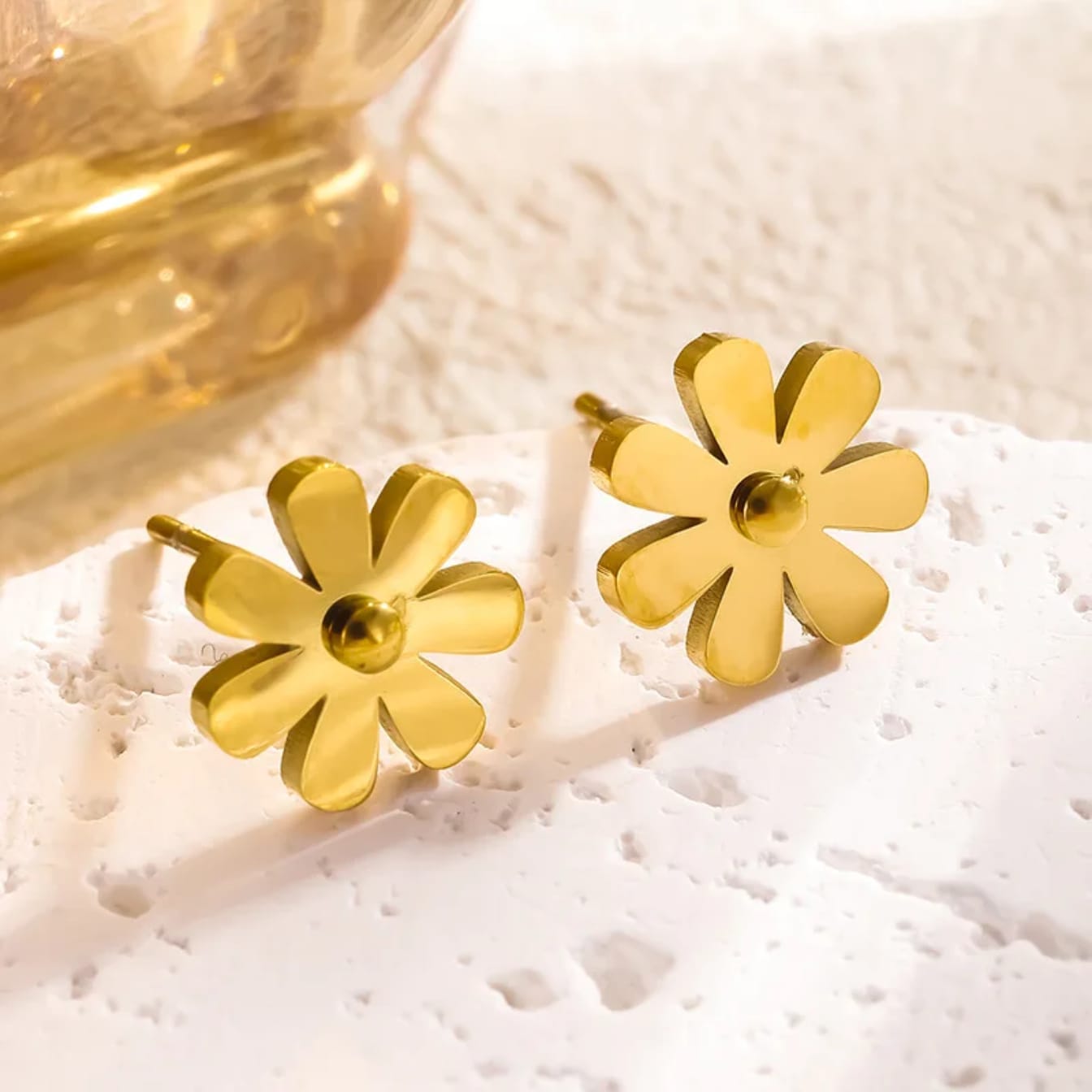 Coco pearls stainless Steel anti tarnish Gold flower-shaped earrings on a textured white surface