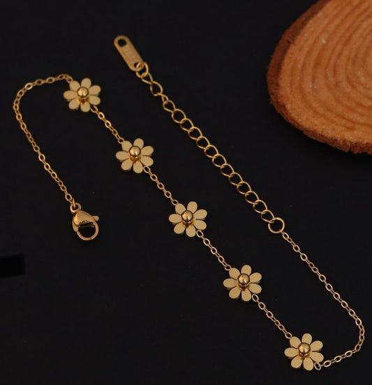 Coco pearls stainless steel Gold bracelet with flower-shaped charms on a dark background