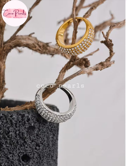 Coco pearls stainless Steel anti tarnish Two wide band rings by Coco Pearls, one in yellow gold and one in silver, both featuring a pavé-set crystal design on the front half. 
