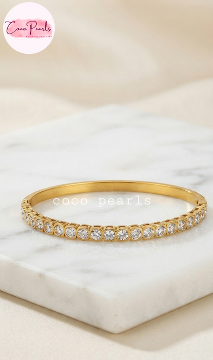 Coco pearls stainless Steel anti tarnish gold diamond accent handcuff displayed on simple background 