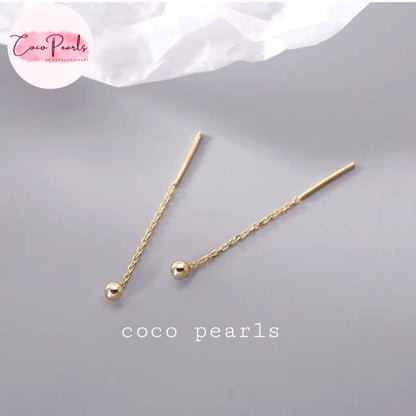 Coco pearls stainless Steel anti tarnish pair of gold-toned drop earrings with a twisted chain and a small polished bead, displayed on a light gray surface