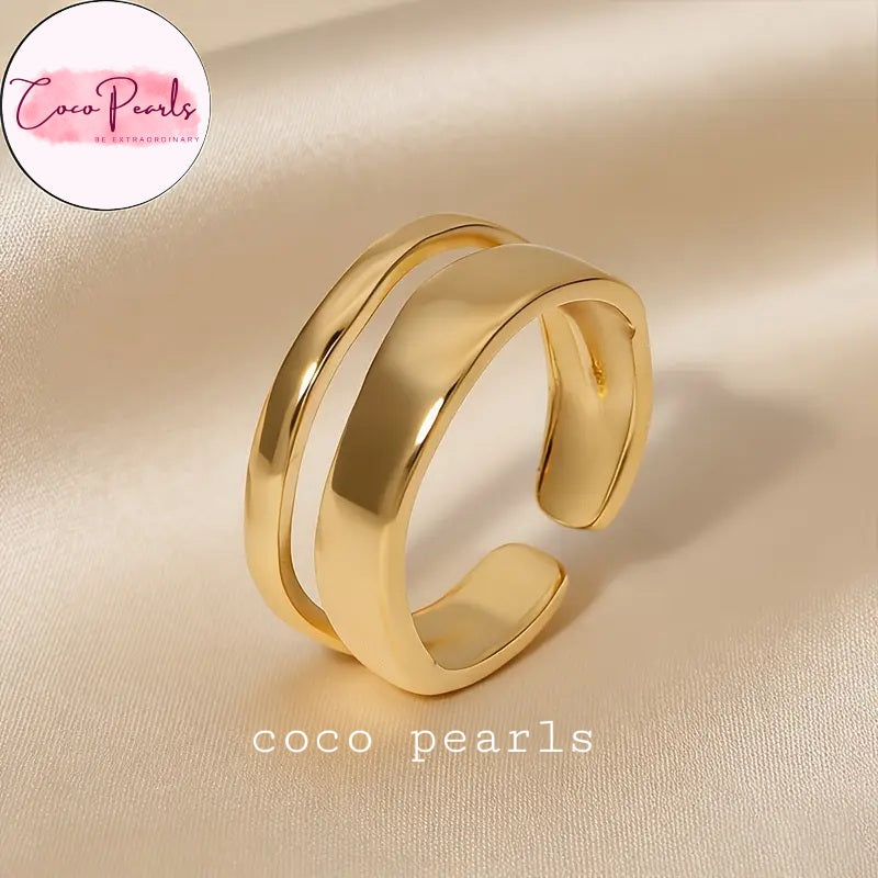 Coco pearls stainless Steel anti tarnish gold dual wave ring displayed on simple background 