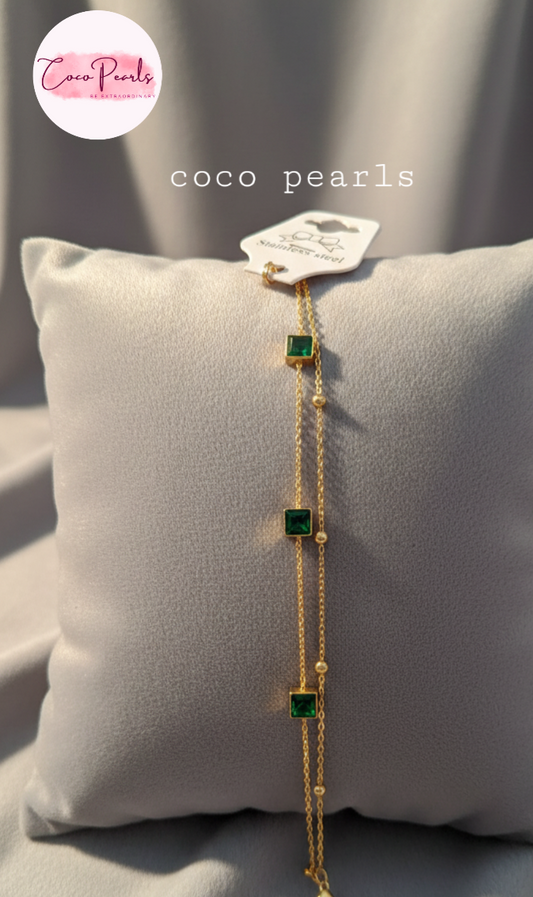 Coco Pearls Stainless Steel Anti Tarnish Gold emerald trio bracelet with three green gemstones on a grey surface 