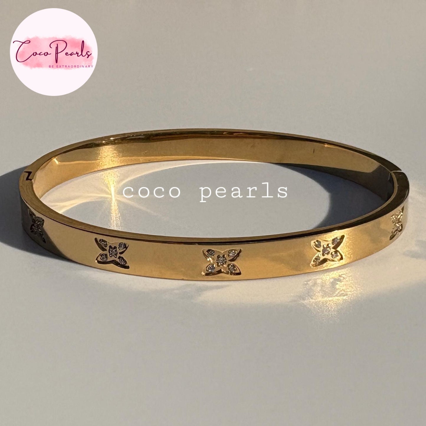 Coco pearls stainless Steel anti tarnish gold flutter handcuff bracelet displayed on simple background 