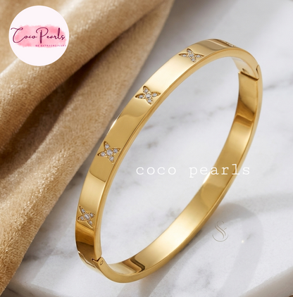 Coco pearls stainless Steel anti tarnish gold  flutter handcuff dimaond studded displayed on simple background 