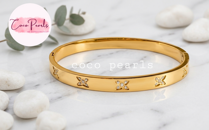 Coco pearls stainless Steel anti tarnish gold  flutter diamond studded handcuff displyed on simple background 