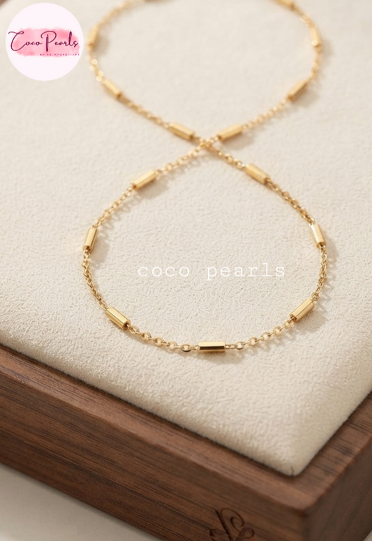 Coco pearls stainless Steel anti tarnish golden bar chain displayed on simple background 