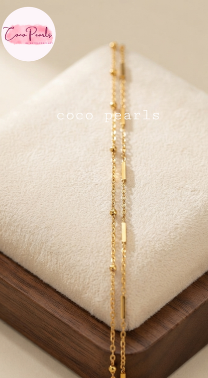 Coco pearls stainless Steel anti tarnish gold bar chain displayed on simple background 