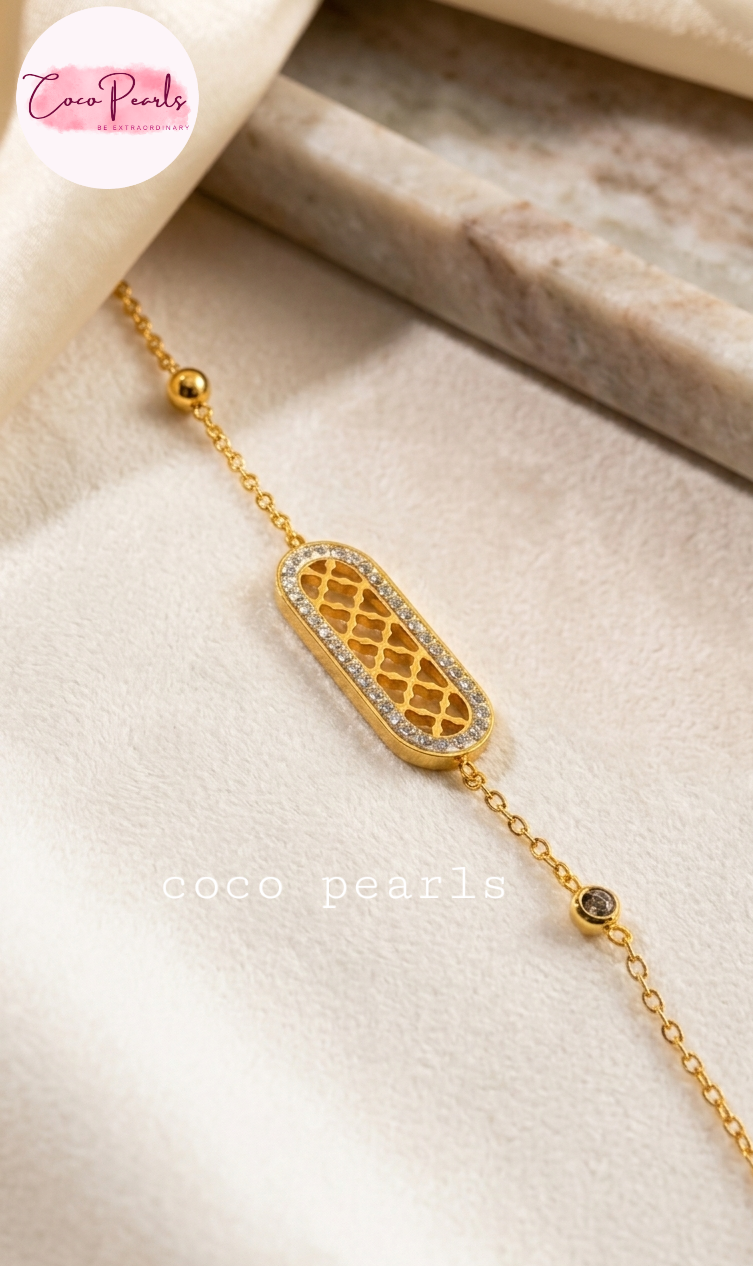 Coco pearls stainless Steel anti tarnish Gold halo bracelet with a decorative clasp on a beige surface
