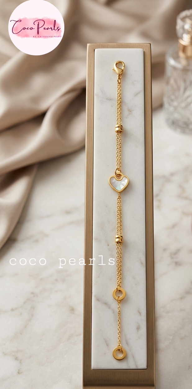 Coco pearls stainless Steel anti tarnish Gold bracelet with heart and circle charms on a marble surface