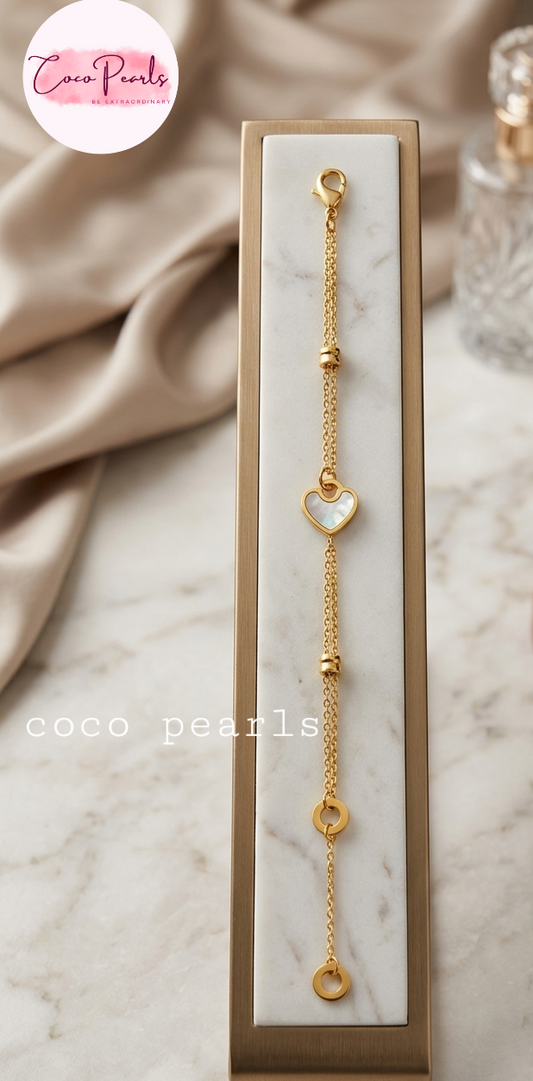 Coco pearls stainless Steel anti tarnish Gold bracelet with heart and circle charms on a marble surface