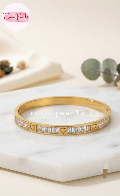 Coco pearls stainless Steel anti tarnish diamomd studded and heart engraved handcuff displayed on marble slab
