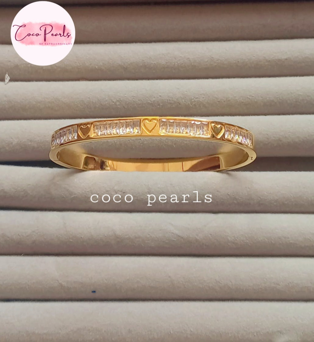 Coco pearls stainless Steel anti tarnish diamond studded heart engraved andcuff displayed on simple background 