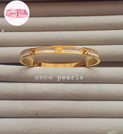 Coco pearls stainless Steel anti tarnish diamond studded heart engraved andcuff displayed on simple background 
