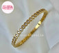 Coco pearls stainless Steel anti tarnish gold bangle bracelet with a continuous row of small clear stones in a hexagonal setting, displayed on a soft white fabric background.