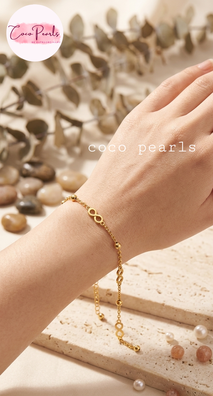 Coco pearls stainless Steel anti tarnish A delicate gold chain bracelet with circular link details and a small charm, shown worn on a person's wrist. 
