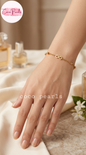Coco pearls stainless Steel anti tarnish A gold infinity bracelet worn on a woman's wrist, shown in a styled lifestyle setting with draped cream fabric