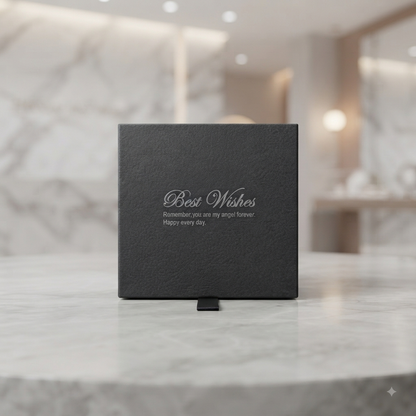 A square dark grey textured gift box with black printed text reading 'Best Wishes Remember you are my angel forever. Happy every day.