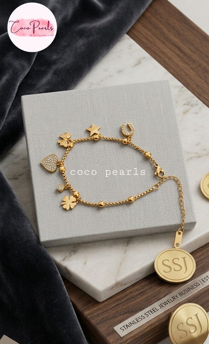 Coco pearls stainless Steel anti tarnish delicate gold charm bracelet with flower, star, and heart charms, displayed on a gray jewelry box.