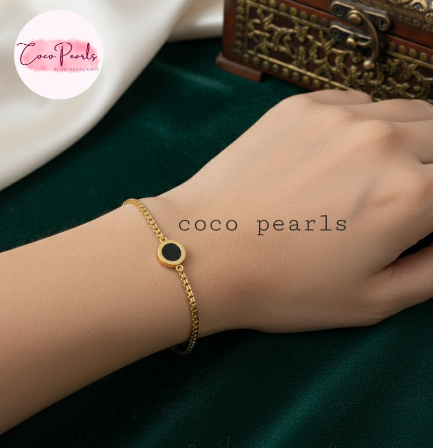 stainless steel anti tarnish Gold midnight aura bracelet with a black circle on a wrist