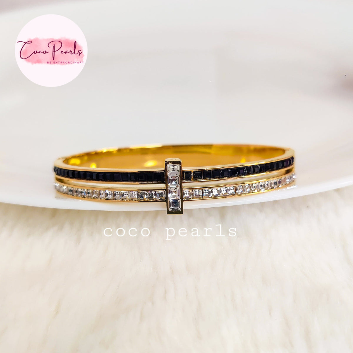 Coco pearls stainless Steel anti tarnish gold-plated double stack bangle bracelet with one black stone row and one clear stone row, featuring a central gold-toned bar with three clear stones.