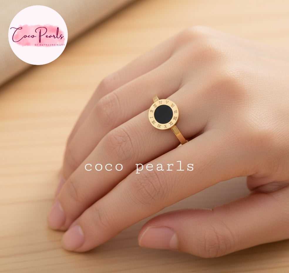 Coco pearls stainless Steel anti tarnish gold ring with a round black center, worn on a hand