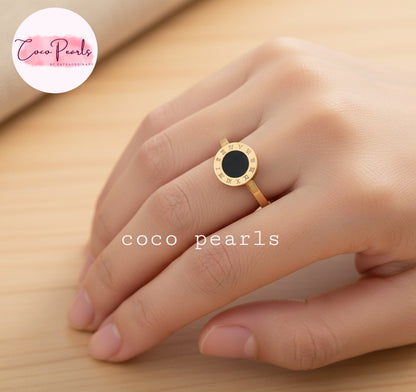 Coco pearls stainless Steel anti tarnish gold ring with a round black center, worn on a hand