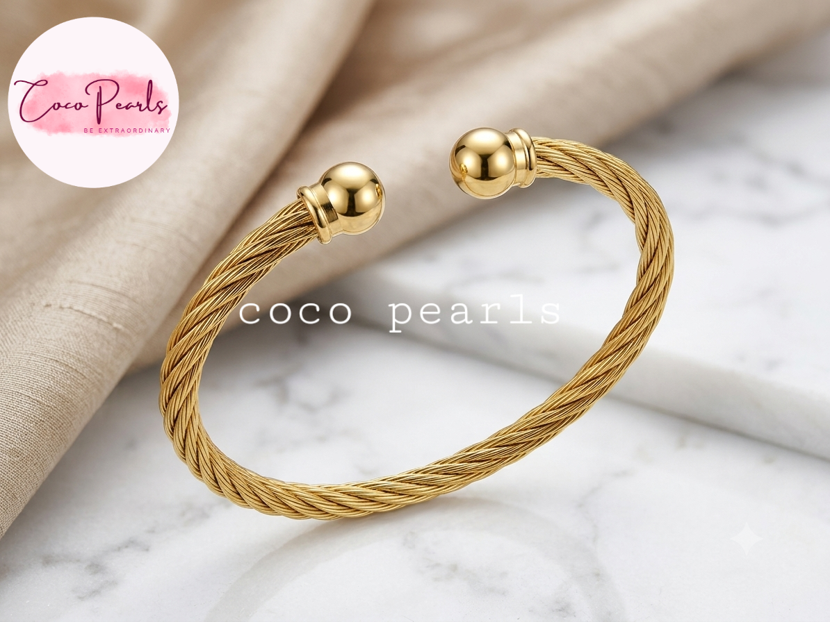 Coco pearls stainless Steel anti tarnish gold orb twist handcuff displyed on simple background 