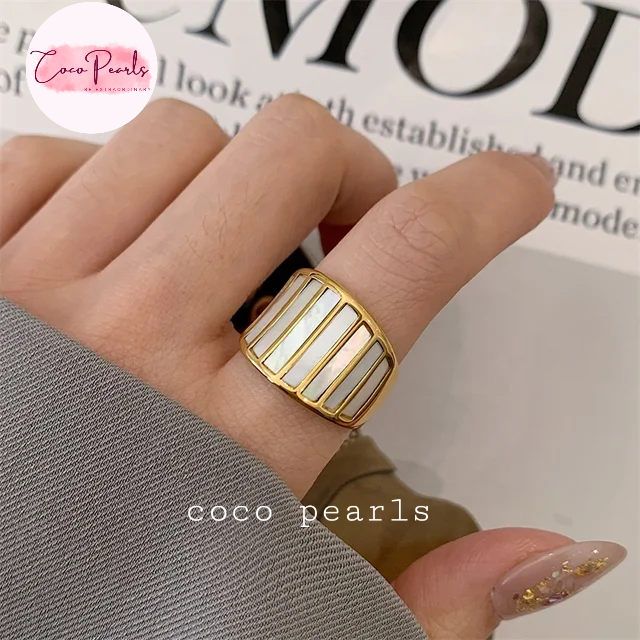 Coco pearls stainless Steel anti tarnish close-up of a hand wearing a wide gold ring with white pearl inlays