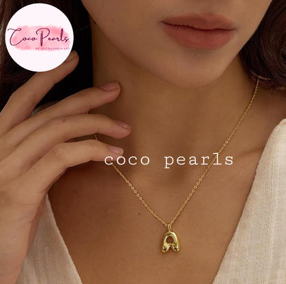 Coco pearls stainless Steel anti tarnish close-up of a model wearing a delicate gold chain necklace with letter 'A' pendant.