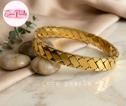 Coco pearls stainless Steel anti tarnish gold  grid handcuff displayed on simple background 