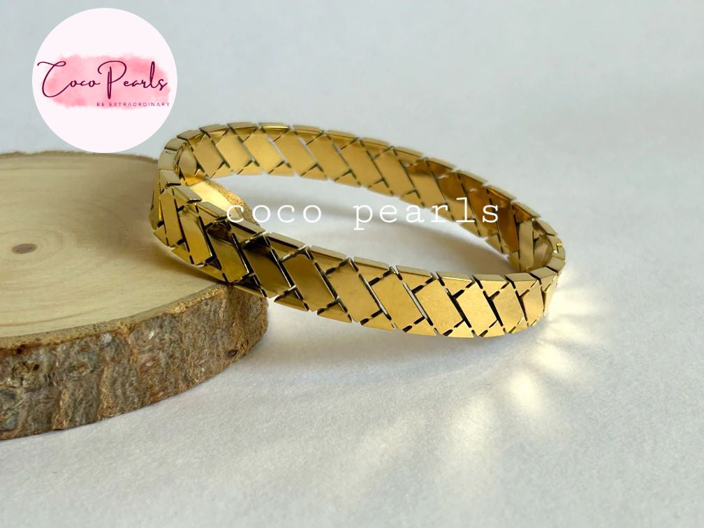 Coco pearls stainless Steel anti tarnish gold regal grid handcuff displayed on simple background 