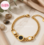 Coco pearls stainless Steel anti tarnish Gold chain bracelet with black and white circular accents on a marble surface