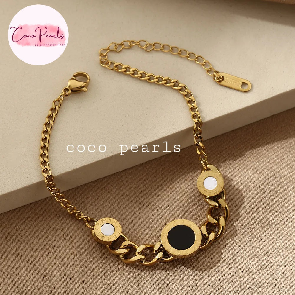 Coco pearls stainless Steel anti tarnish Gold chain bracelet with round embellishments on a beige surface