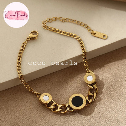 Coco pearls stainless Steel anti tarnish Gold chain bracelet with round embellishments on a beige surface