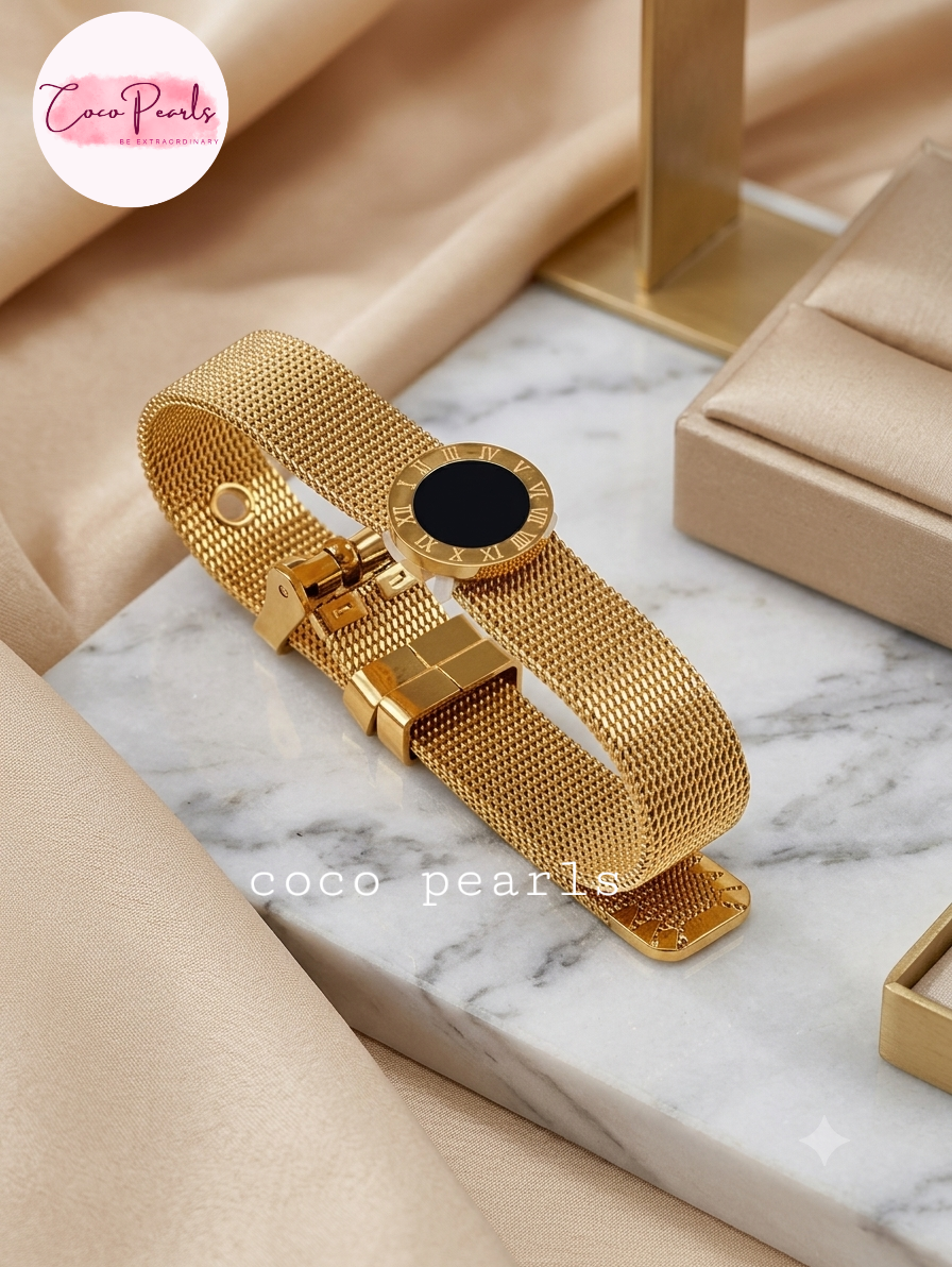 Coco pearls stainless Steel anti tarnish gold roman chain bracelet with black roman dial displayed on marble surface 