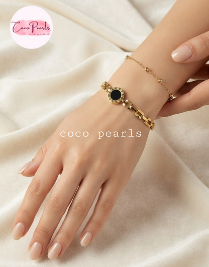 Coco pearls stainless Steel anti tarnish black roman dial in center with watch chain displayed on hand 