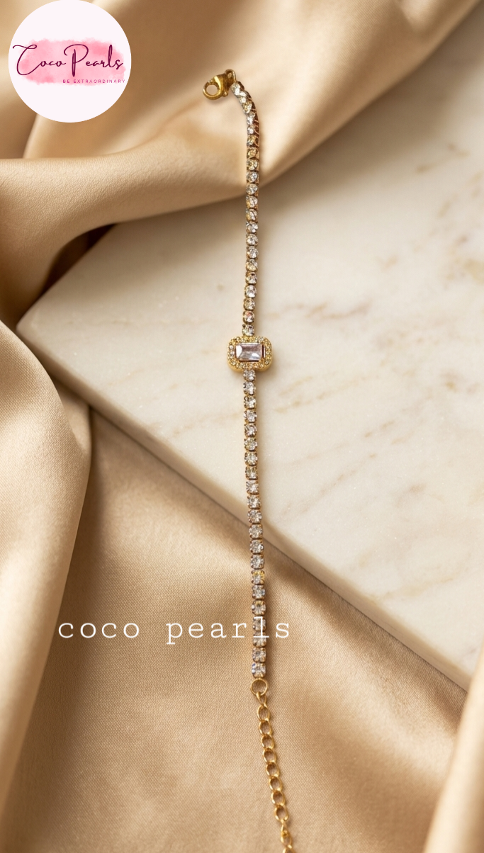 Coco pearls stainless Steel anti tarnish gold royale crown diamond studded bracelet displayed on simple background 