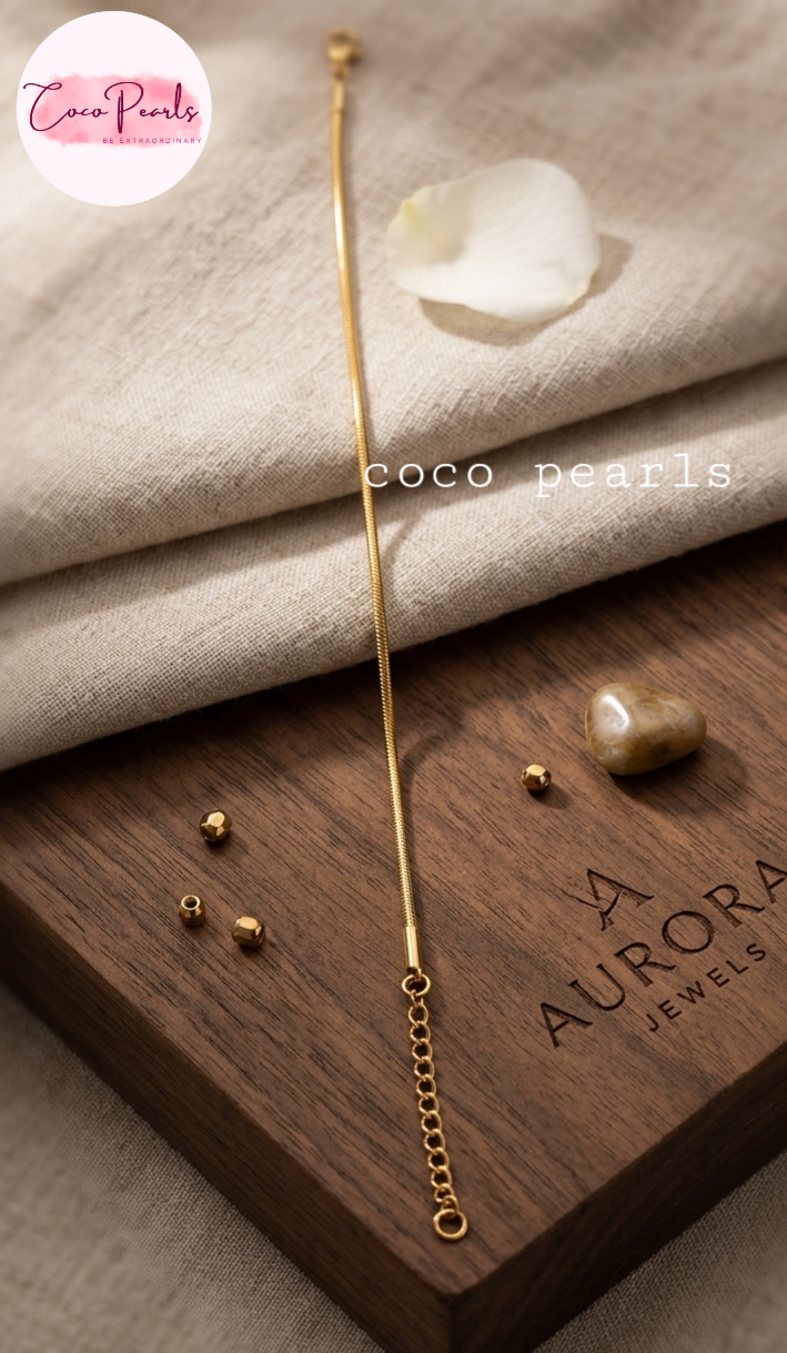 Coco pearls stainless Steel anti tarnish gold-toned bracelet with a round snake chain bracelet on simple background 