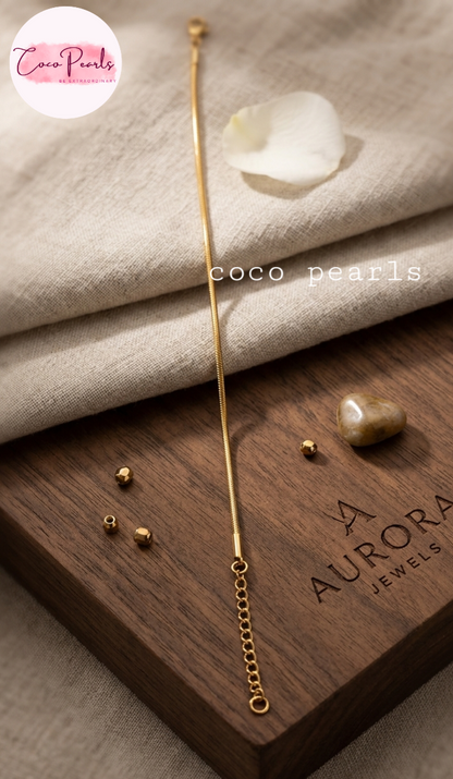 Coco pearls stainless Steel anti tarnish gold-toned bracelet with a round snake chain bracelet on simple background 