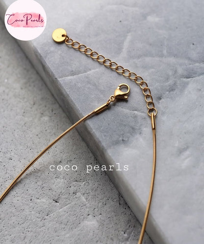 Coco pearls stainless Steel anti tarnish Gold chain bracelet with a lobster clasp and adjustable extension chain, displayed on a gray stone