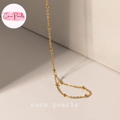 Coco pearls stainless Steel anti tarnish gold small ball chain hand harness displayed on simple background 