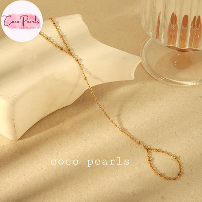 Coco pearls stainless Steel anti tarnish gold small ball chain hand harness displayed on simple background 