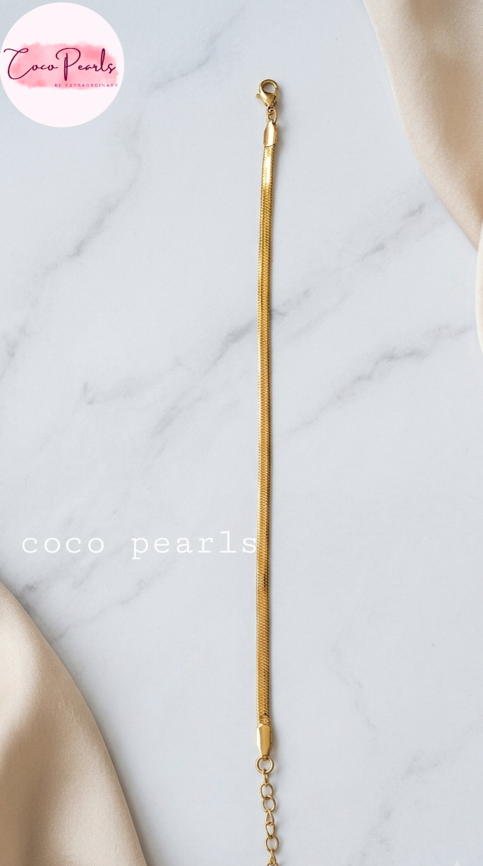 Coco pearls stainless Steel anti tarnish gold  thin snake chain bracelet displayed on simple background 