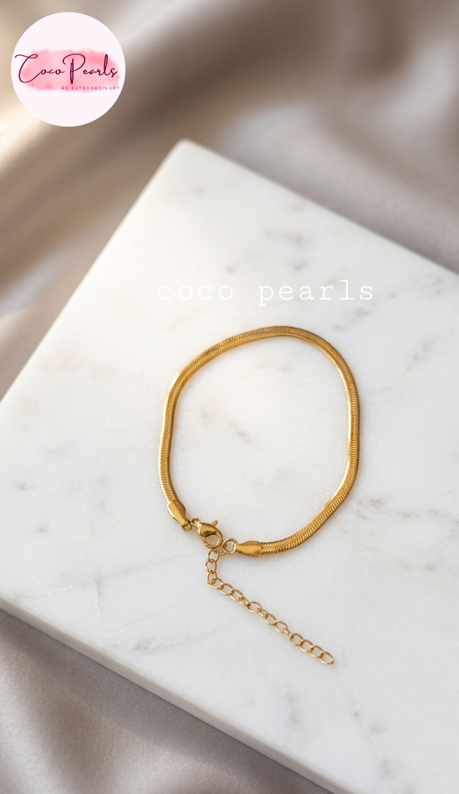 Coco pearls stainless Steel anti tarnish gold thin snake chain bracelet displayed on simple background 
