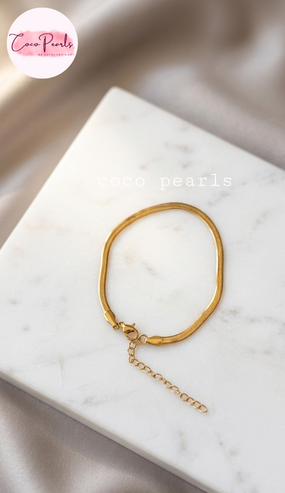 Coco pearls stainless Steel anti tarnish gold thin snake chain bracelet displayed on simple background 