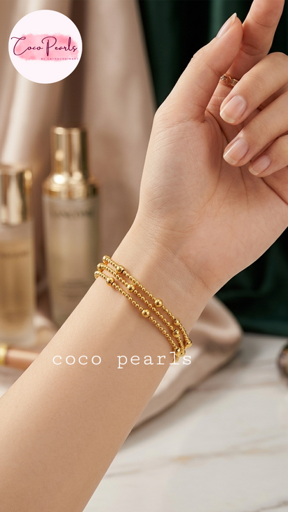 Coco Pearls stainless Steel anti tarnish close-up of a person's wrist wearing three delicate gold beaded bracelets