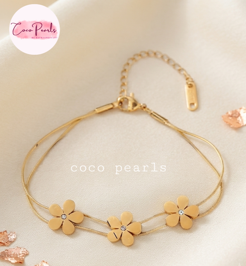 Coco pearls stainless Steel anti tarnish gold  triple flower bracelet with double chain displayed on simple background 