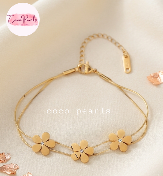 Coco pearls stainless Steel anti tarnish gold  triple flower bracelet with double chain displayed on simple background 
