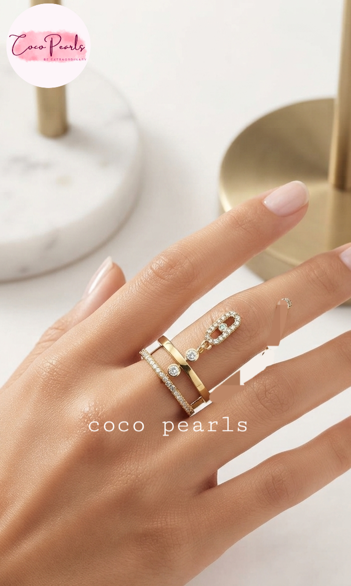 Coco pearls stainless Steel anti tarnish close-up of a hand wearing three stacked rings by Coco Pearls, featuring gold bands with clear pavé and diamond accents, set against a soft, light background